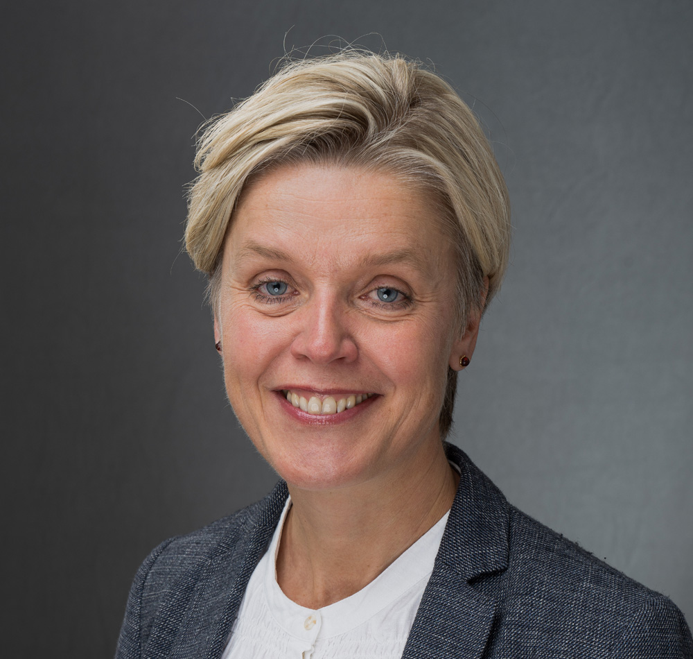 En kvinne som smiler til kameraet