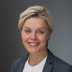 En kvinne som smiler til kameraet