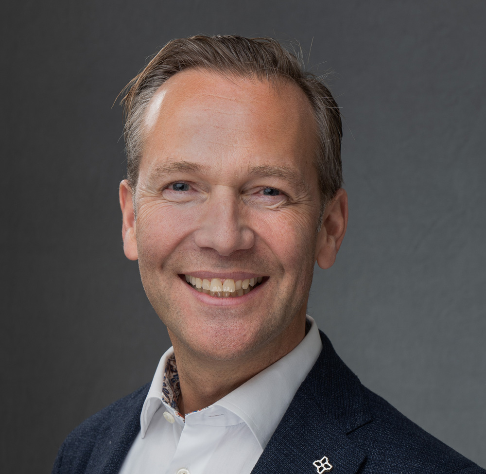 En mann som smiler til kameraet