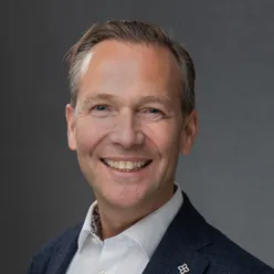 En mann som smiler til kameraet