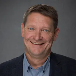 En mann som smiler til kameraet