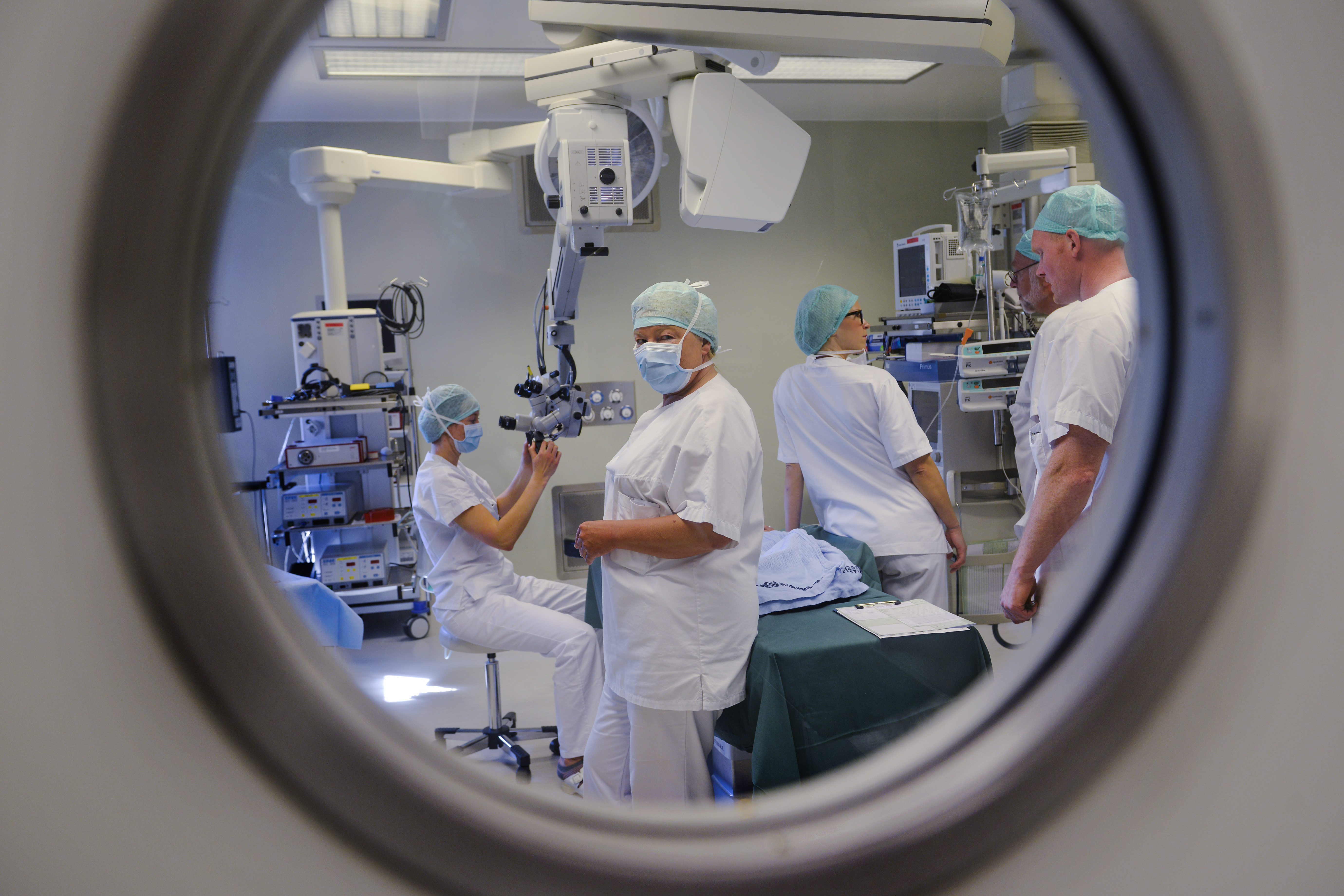 En gruppe mennesker i hvite labfrakker som arbeider i et rom