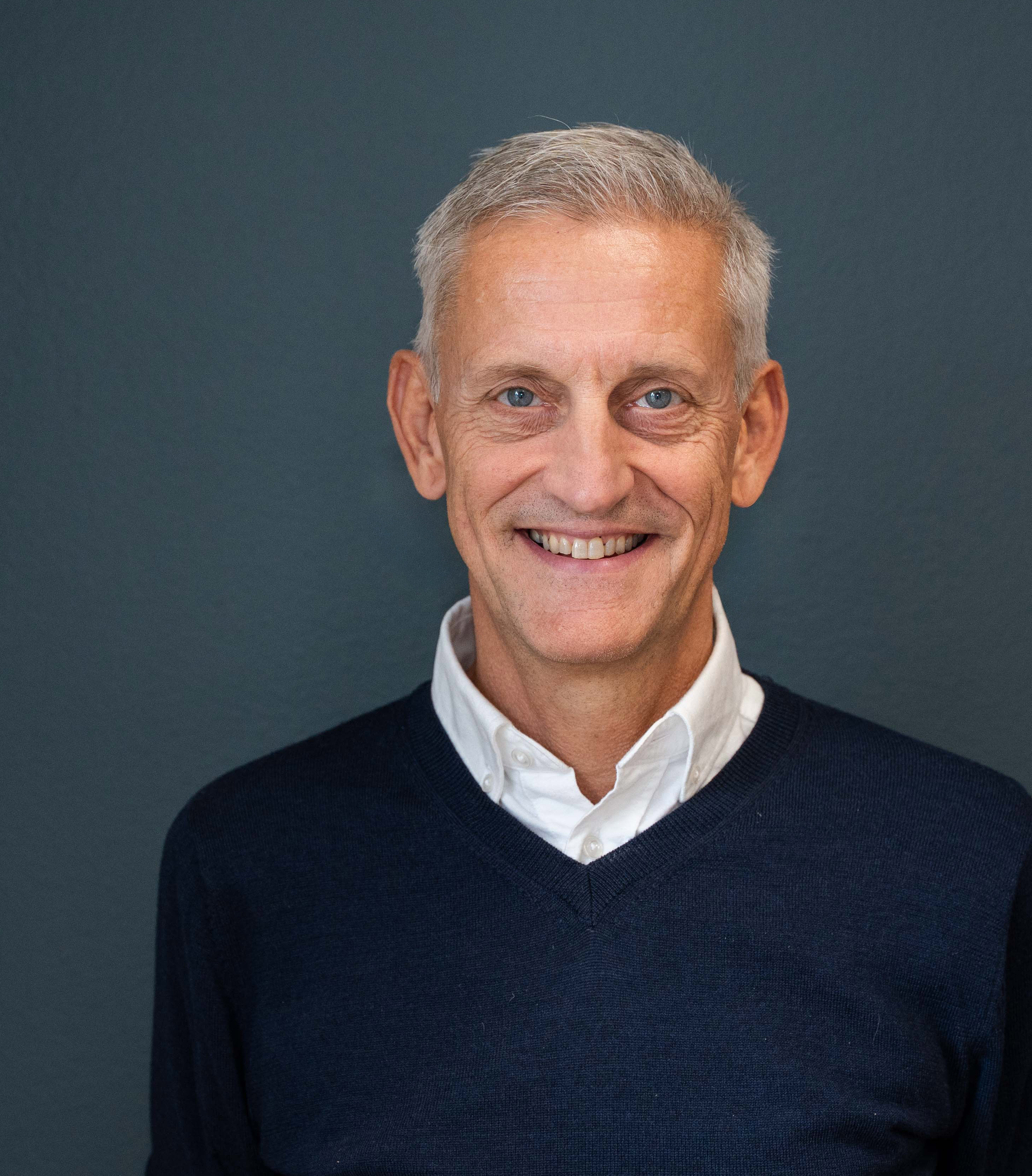 En mann som smiler mot kamera