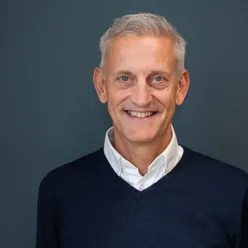 En mann som smiler mot kamera