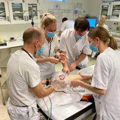 Et team av leger i hvit uniform øver seg på simulerte hendelser. Foto