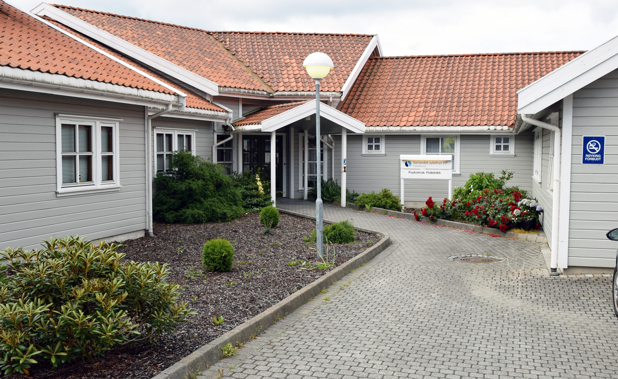 En innkj&oslash;rsel med et hus og et skilt p&aring; den