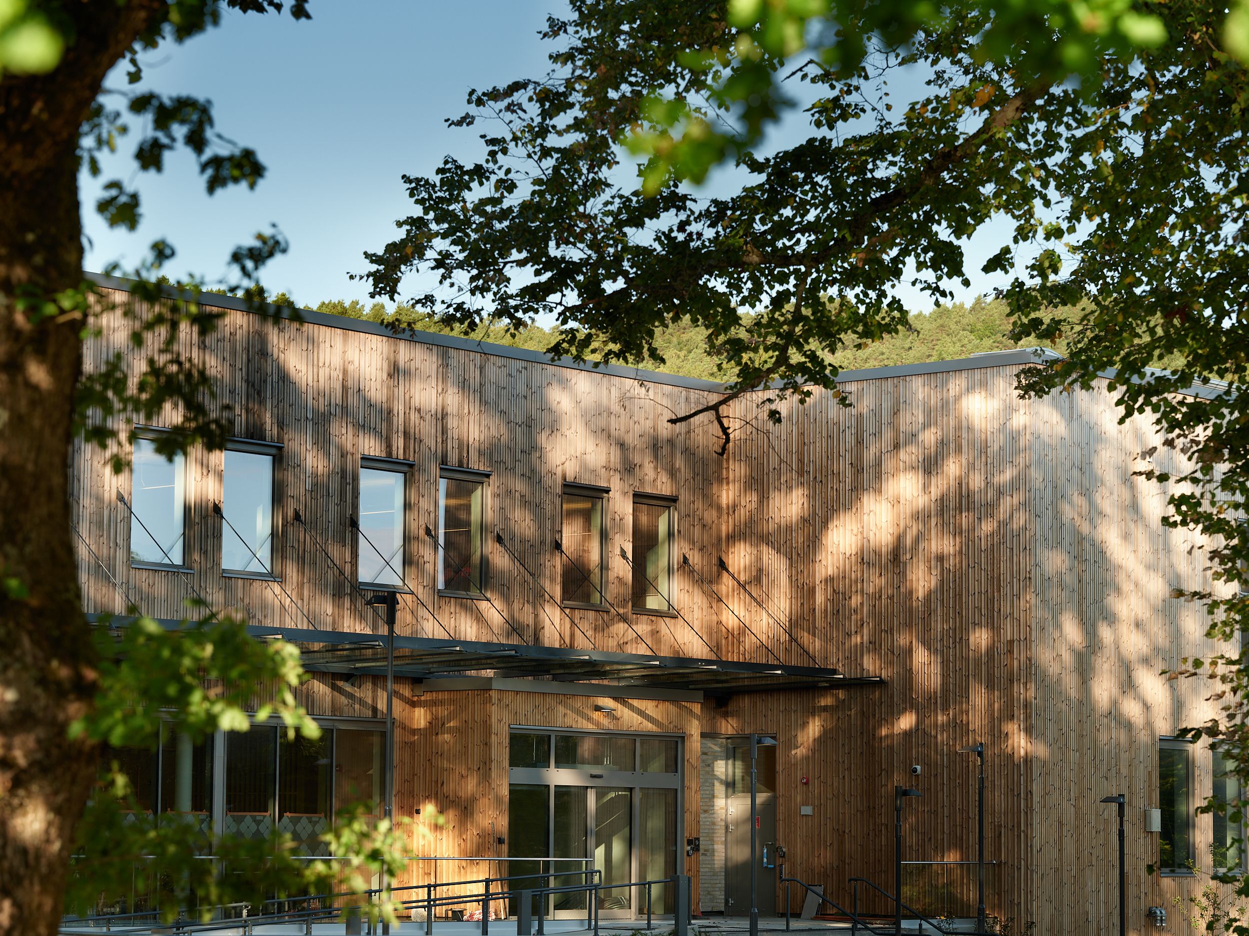 Nybygg psykisk helse inngangsparti i gr&oslash;nne omgivelser. Foto.