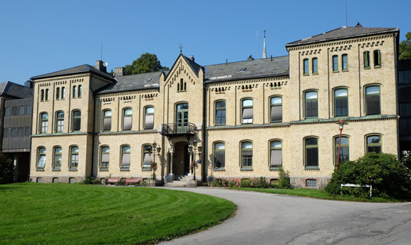 En stor bygning med en plen foran seg