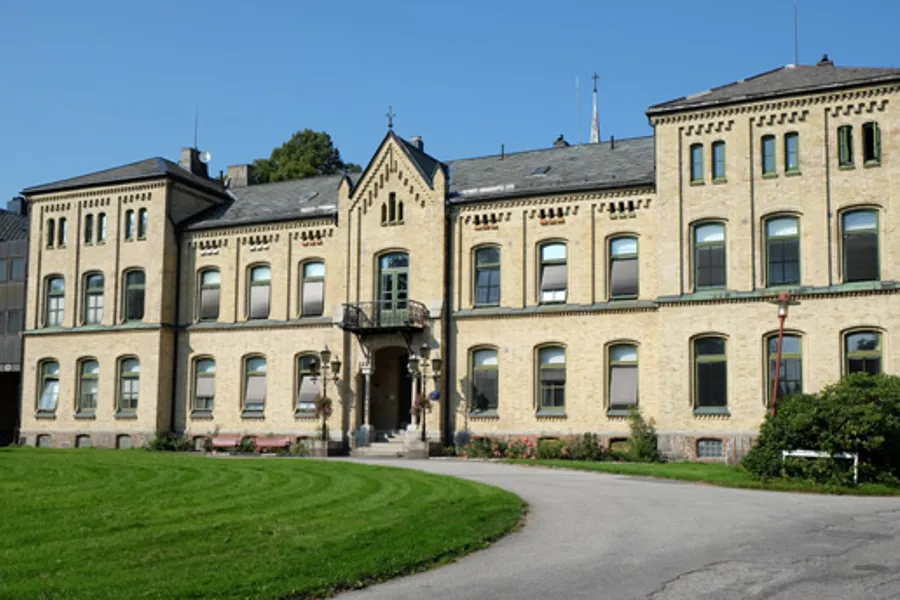 En stor bygning med en plen foran seg