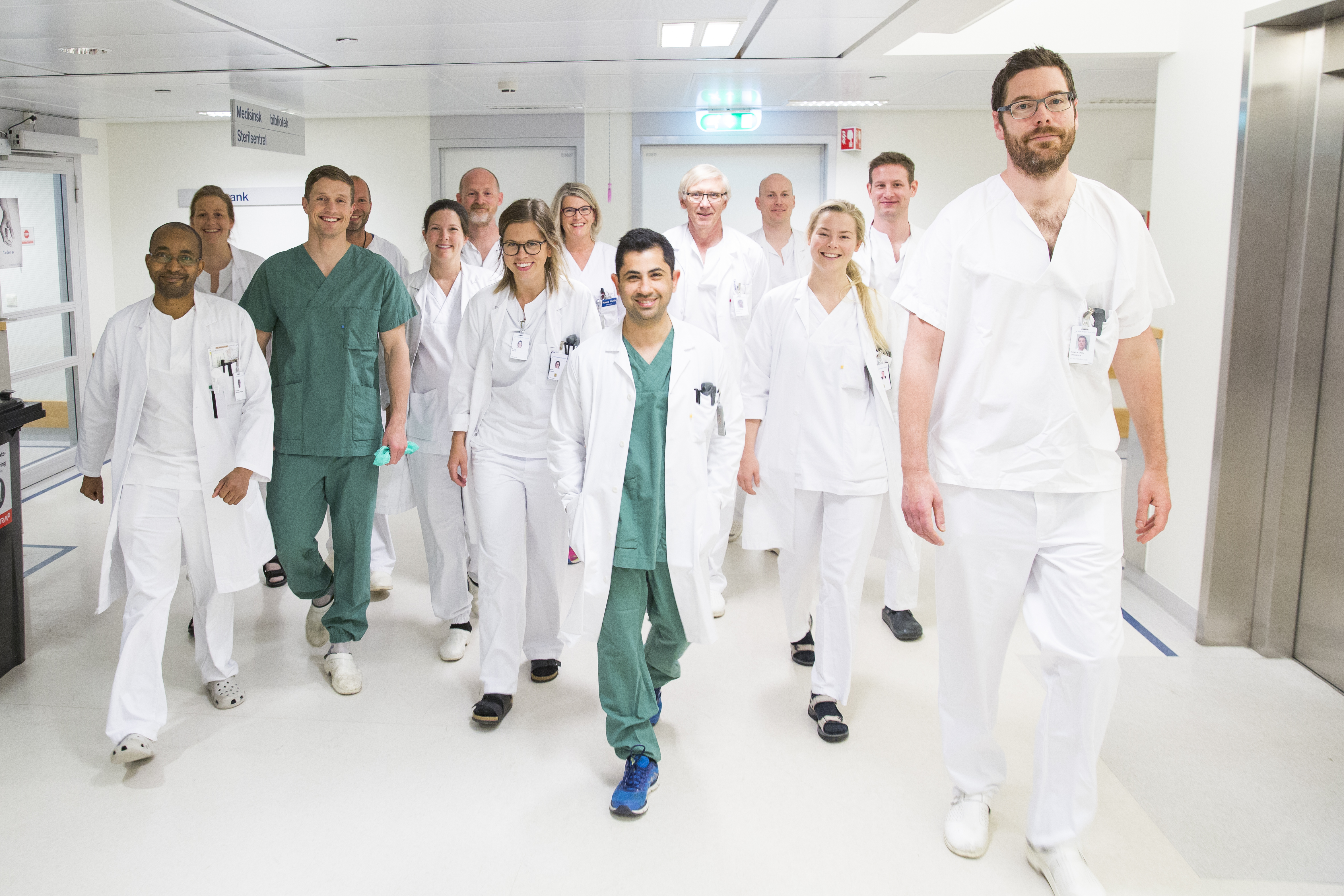 Ansatte ved sykehuset g&aring;r sammen p&aring; jobb. Foto.