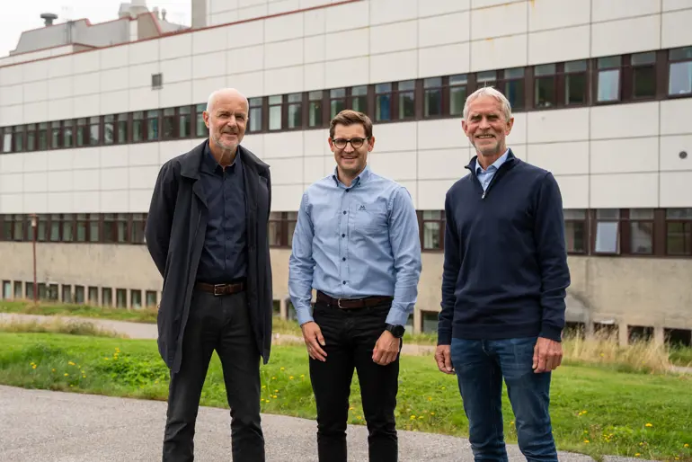 Tre menn foran sykehusbygning